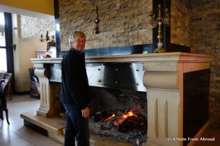 Tim warming up by a massive fireplace